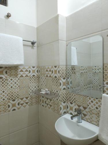 a bathroom with a sink and a mirror at Hotel Kashi Remark Suites By G K Group in Varanasi