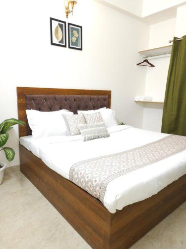 a bedroom with a large bed with white sheets at Hotel Kashi Remark Suites By G K Group in Varanasi