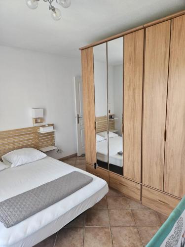 a bedroom with a bed and a large wooden cabinet at Maison à 700m de la mer in Bormes-les-Mimosas