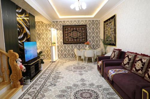 a living room with a couch and a tv at OSMAN villa in Samarkand