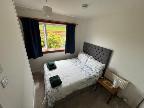 a small bedroom with a bed and a window at Ashfield in Breakish