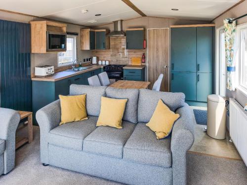 a living room with a couch and a kitchen at Peachy in Heysham