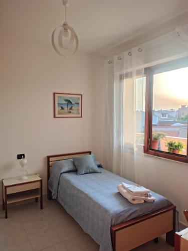 a bedroom with a bed and a window at "Da Carla e Sandro"- Appartamento con parcheggio privato in Quartucciu