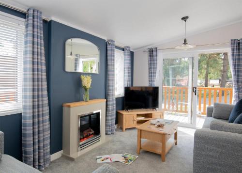 a living room with a fireplace and a tv at Thorness Bay in Porchfield