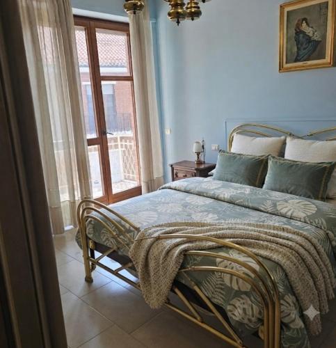 a blue bedroom with a bed with a window at B apartments LUXURY in Case Bruciate