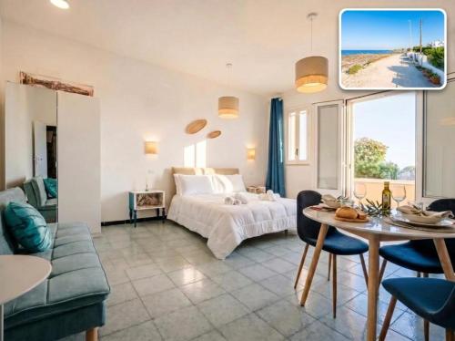 a bedroom with a bed and a table and a couch at SanVitoStea Seafront Apartments in San Vito