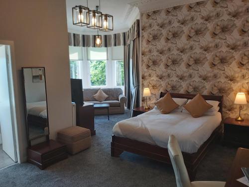a bedroom with a bed and a living room at The Strathearn Hotel in Fife