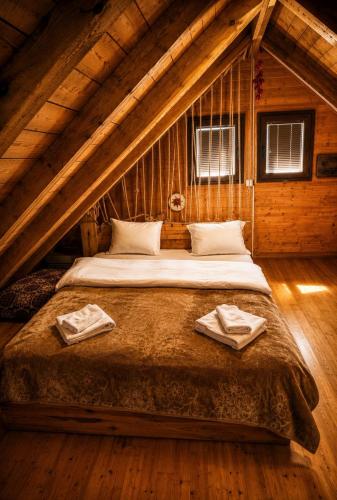 a bedroom with a large bed in a attic at Scardus Lodge in Tetovo