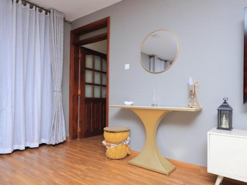 a bathroom with a table and a mirror on the wall at Nassiwa Aisha in Kampala