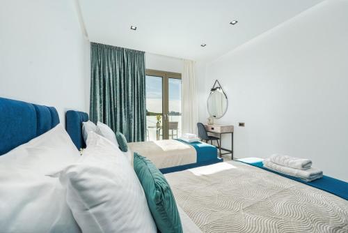 a bedroom with two beds and a mirror at Luminoza Villa Zakynthos in Volímai
