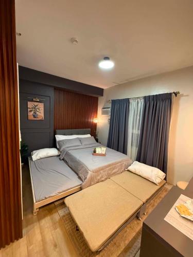 a bedroom with two beds and a desk at D&J Cozy Family Studio Bacolod City in Bacolod