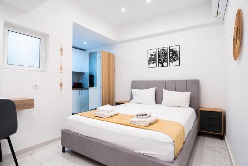 a bedroom with a large bed with two towels on it at Syntagma Luxury Suites 1 in Athens