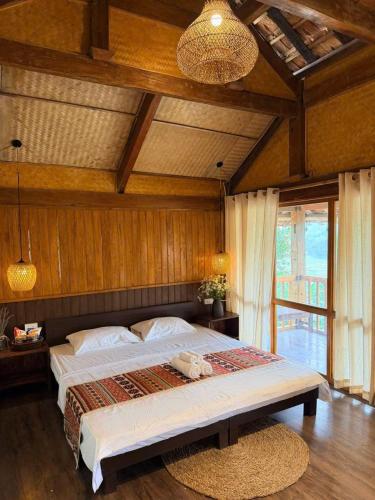 a bedroom with a large bed in a room at Bản Bọc Chăm Chứng in Làng Vach