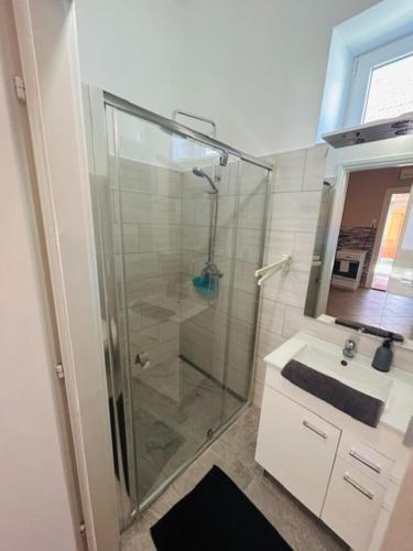 a bathroom with a glass shower and a sink at Csuszka vendégház in Tiszafüred