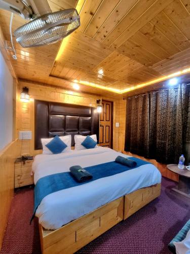 a bedroom with a large bed with a wooden ceiling at K2 Alpine Hotel in Pahalgām