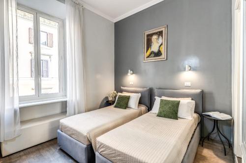 two beds in a small room with a window at Hotel Castelfidardo in Rome