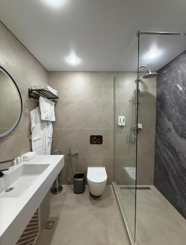 a bathroom with a shower and a toilet and a sink at Na More Центр Семейного Отдыха in Kapchagay
