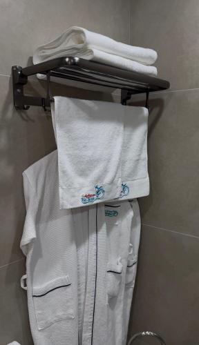 a group of white towels on a rack in a bathroom at Na More Центр Семейного Отдыха in Kapchagay