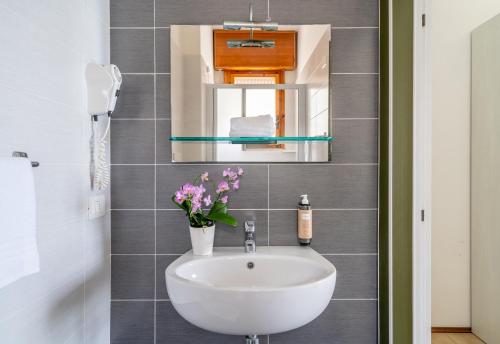 a bathroom with a sink and a mirror at Hotel Embassy in Pesaro