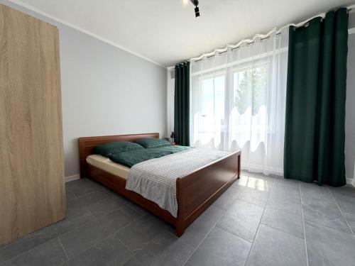 a bedroom with a bed and a large window at Apartament przy Kauli in Inowrocław