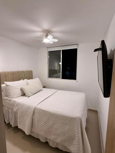 ein Schlafzimmer mit einem weißen Bett und einem Fenster in der Unterkunft Confort155 in Ibagué