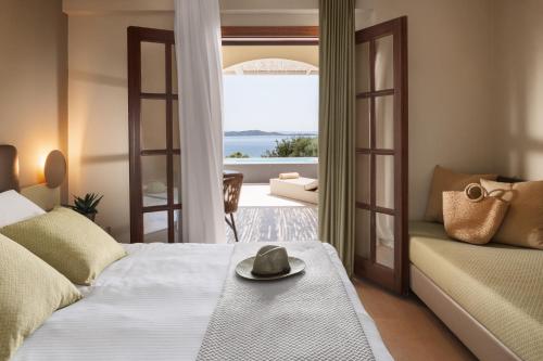 a bedroom with a bed and a view of the ocean at Akrathos Beach Hotel in Ouranoupoli