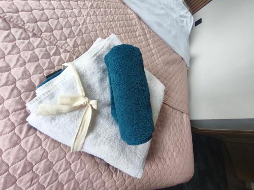a blue sock on a bed with a white towel at Apartamenty RETRO FV in Koszalin