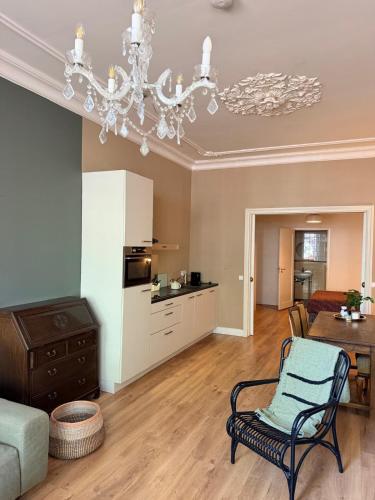 a living room with a chandelier and a table at historic city apartment with private parking in Gouda