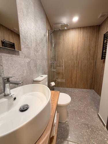 a bathroom with a white sink and a toilet at Crown Apartment Secret Corner in Ukmergė