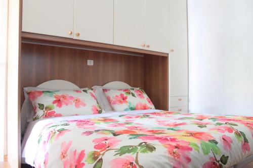 a bedroom with a bed with a floral comforter at Appartamento Stella Marina in Marcelli