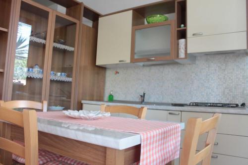a kitchen with a table with a red and white table cloth at Appartamento Stella Marina in Marcelli