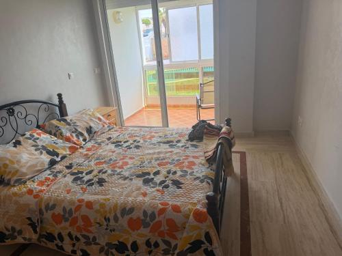 a bedroom with a bed with a flowered comforter at Blu capri in Dar Bouazza