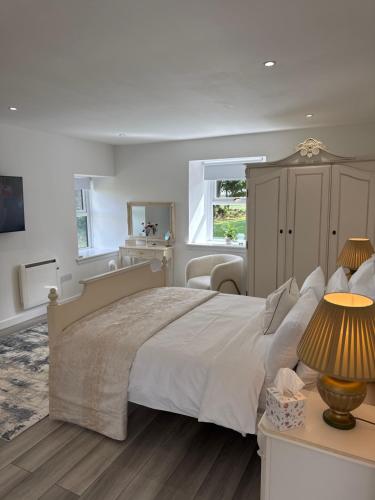 a bedroom with a large bed and a table with lamps at Altons Bothy Guest House in Kinmuck