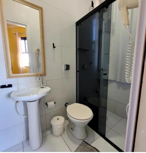a bathroom with a toilet and a sink and a shower at Pousada Nova Onda in Paranaguá