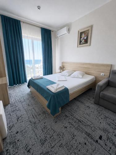 ein Schlafzimmer mit einem Bett, einer Couch und einem Fenster in der Unterkunft Hotel Union in Eforie Nord