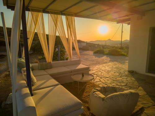 a view of the sunset from a balcony with a couch at Sugarstone House in Adamantas
