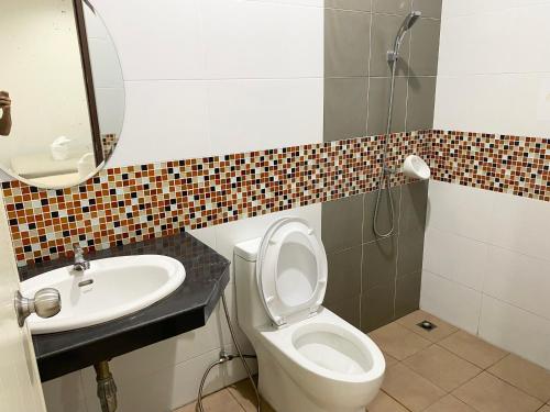 a bathroom with a toilet and a sink and a mirror at singgah homestay yala2 in Ban Sarong