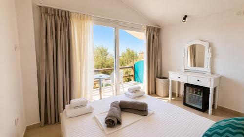a bedroom with a bed and a large window at Drymades Bungalows Adults Only in Dhërmi
