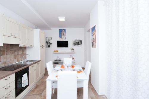 a white kitchen with a white table and chairs at Moresco Agriturismo in Moresco