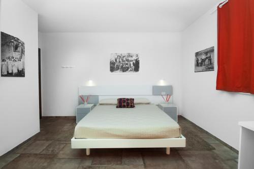 a white room with a bed and two pictures on the wall at Moresco Agriturismo in Moresco