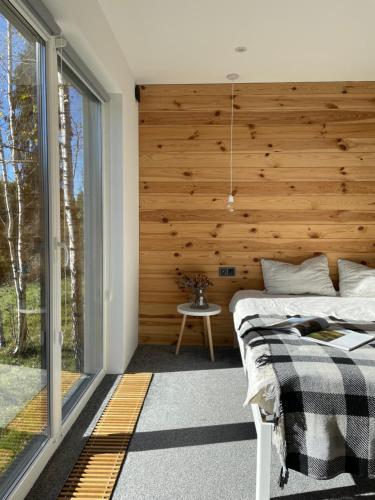 a bedroom with a wooden wall and two beds at Homin riky in Myta