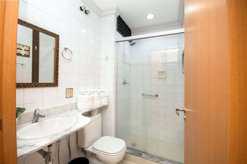 a bathroom with a toilet and a sink and a shower at Hotel Colonial Plaza in Itu