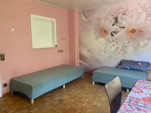 ein Zimmer mit zwei Betten und einer Wand mit Blumen in der Unterkunft Haus Tun in Waldbröl