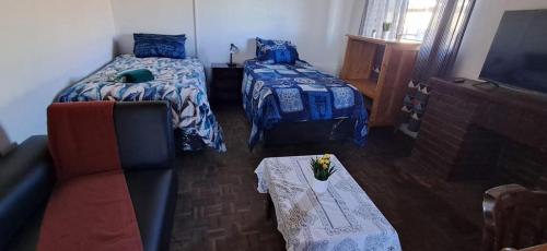 a living room with two beds and a couch at Kuils River Apartment, near Cape Town Airport in Sarepta