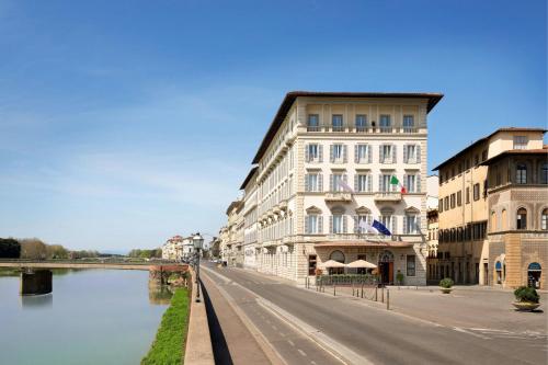 a city street with buildings next to a river at The St. Regis Florence in Florence