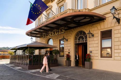 a woman walking in front of a hotel at The St. Regis Florence in Florence