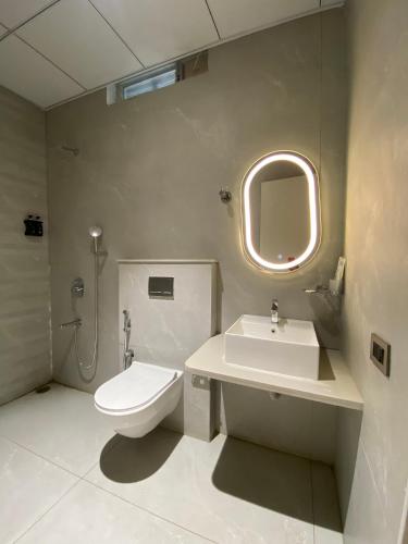 a bathroom with a toilet and a sink and a mirror at Hotel Radhe Imperial in Hyderabad