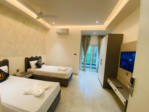 a hotel room with two beds and a television at Hotel Radhe Imperial in Hyderabad