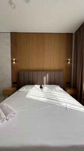 a large white bed in a bedroom with wooden walls at Улы дала in Shymkent