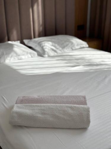 a white bed with two towels on top of it at Улы дала in Shymkent